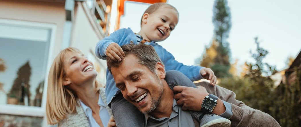 a family smiling and having fun outdoors