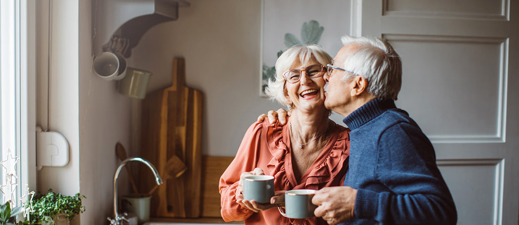 an elderly couple kissing each other on the cheek