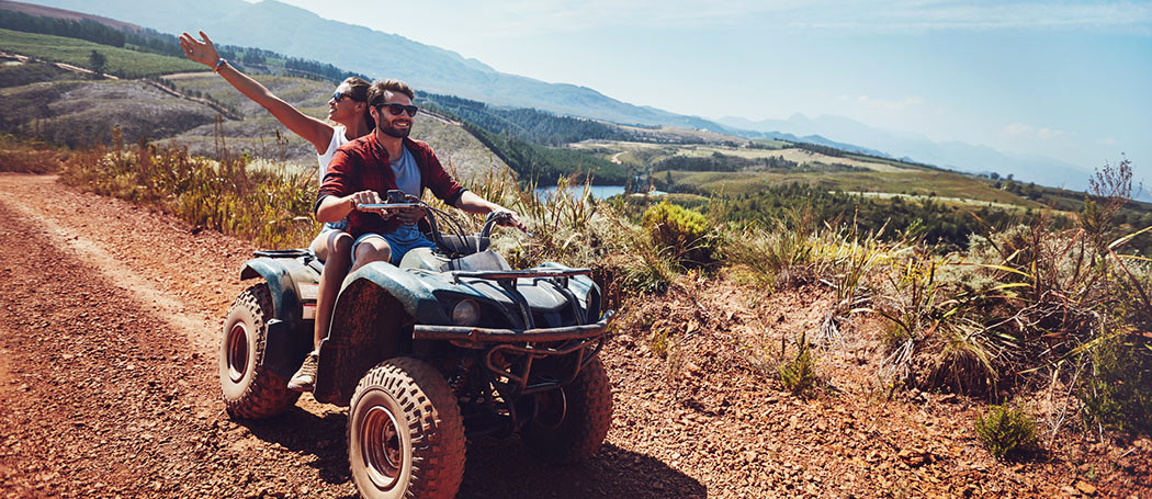 a couple riding an ATV