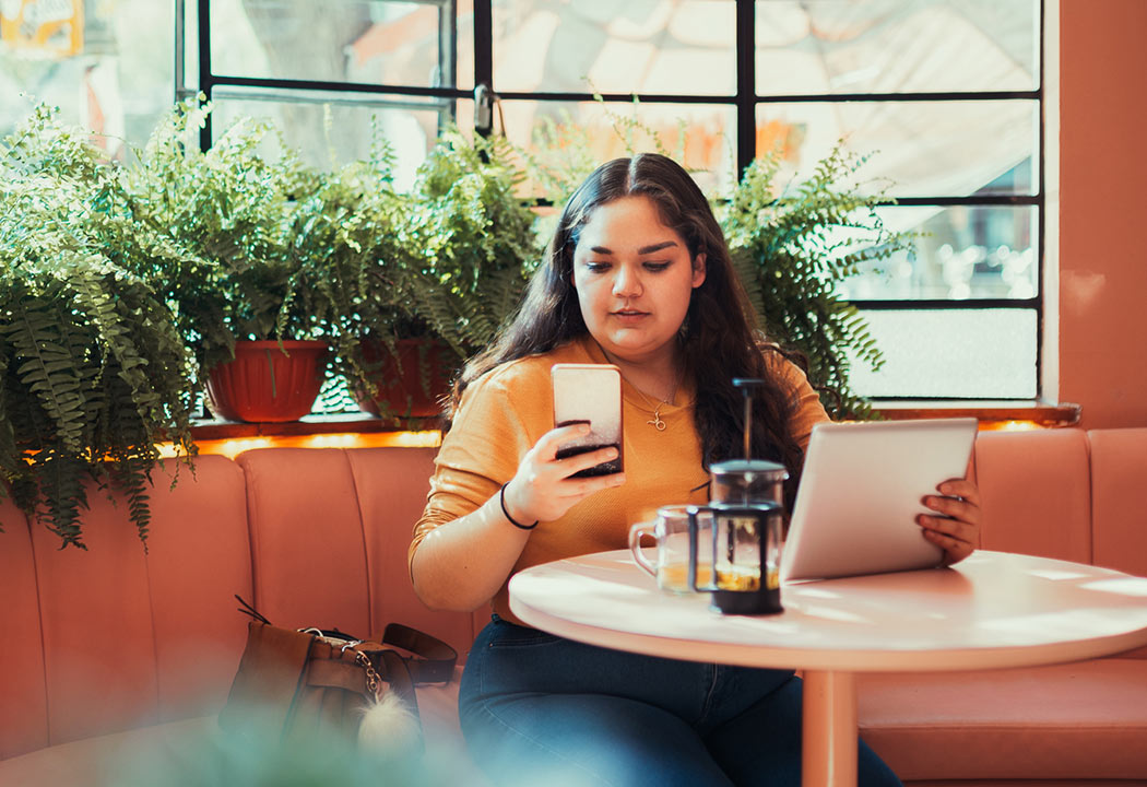 a girl on her mobile phone sitting in a coffee shop