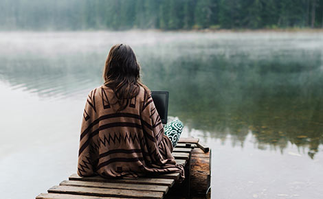 woman sitting on a dock with her laptop